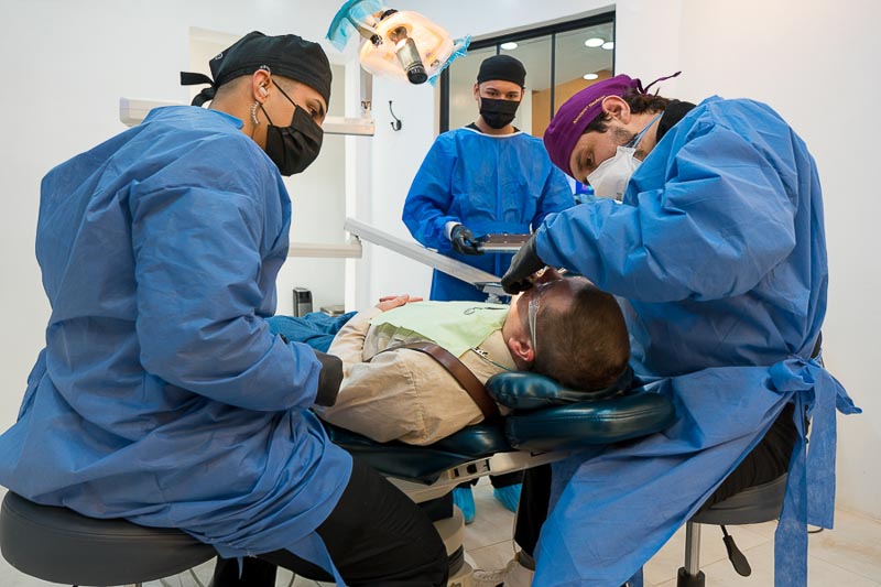Dr. Nestor and 2 dental assistants at SOTA Dental Los Algodones perform surgery on an older male patient.
