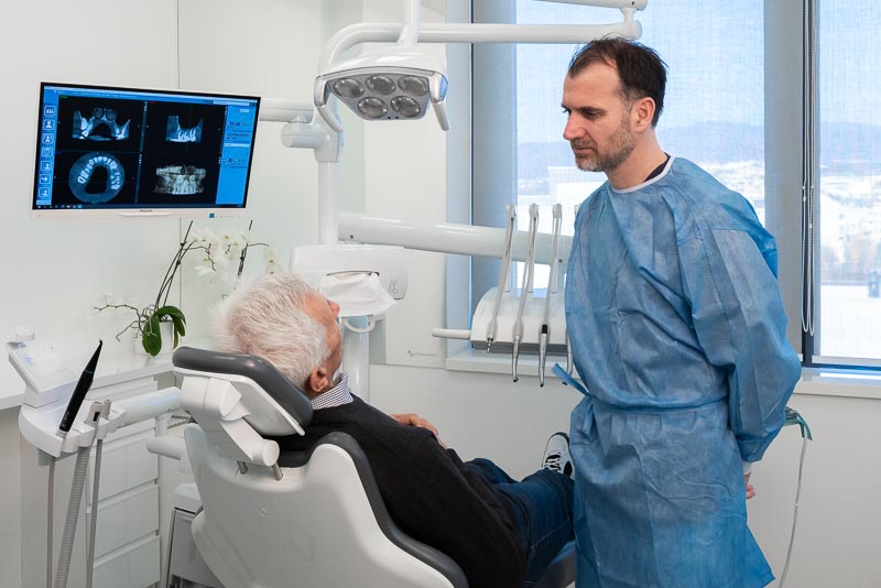 Dr. Bago, a dentist with SOTA Dental in Croatia, talks about dental implants in Croatia with a male patient.
